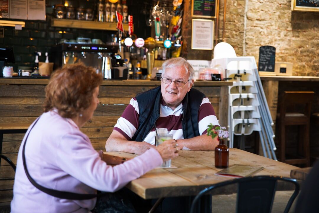 elderly friends chatting at cafe